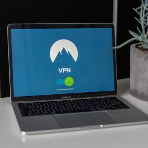 Laptop with VPN screen and a succulent plant on a desk, emphasizing online privacy and security.